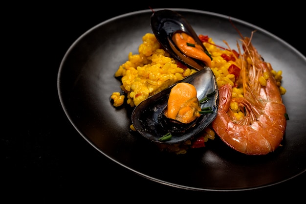 Traditional rice in paella with fish and meat.