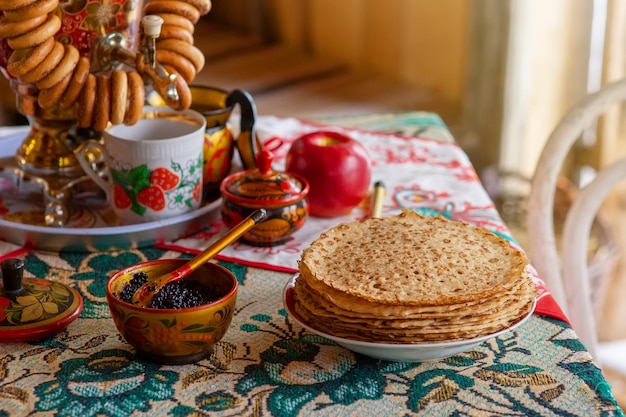 Фото Традиционные русские пирожные с икрой стоят на столе с самоваром