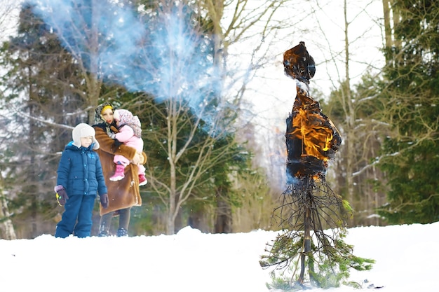 春先の伝統的なロシアの休日。冬を見送ります。マルディグラ。公園で冬に子供と家族。