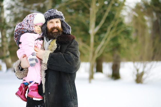 Traditional Russian holiday in early spring. Seeing off winter. Mardi gras. Family with children in the winter in the park.