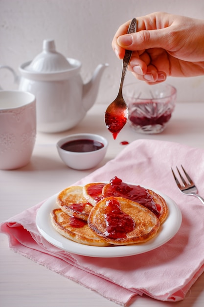 Traditional Russian Oladyi or pancakes with raspberry jam