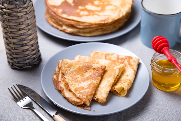 벌 꿀과 전통적인 러시아 팬케이크입니다. Shrovetide. Maslenitsa 주. 선택적 초점, 근접.