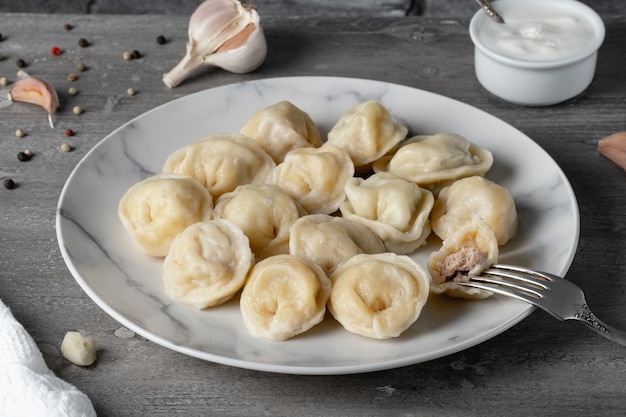 Traditional russian pelmeni ravioli dumplings with meat on a wooden table