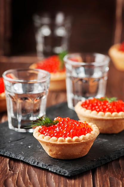 Traditional russian red caviare on the wooden table