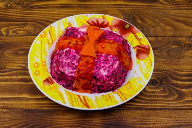 Traditional russian salad Herring under a fur coat shuba on wooden table Salad made in a shape of gift box