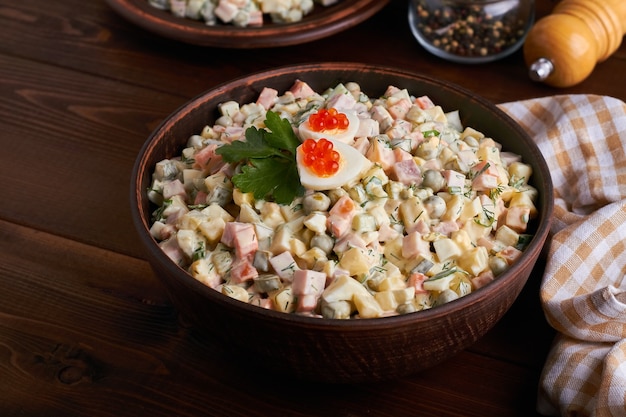 Traditional russian salad (olivier) dark brown background