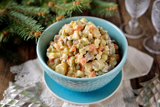 Traditional Russian salad Olivier on an old wooden background