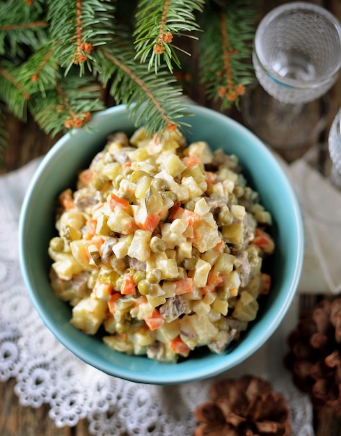 Insalata russa tradizionale olivier su un vecchio fondo di legno