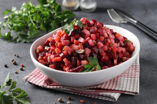 Traditional Russian salad Vinaigrette of beets potatoes carrots beans pickles onions and vegetable oil on gray background Vegetarian food