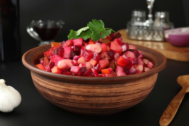 Foto tradizionale vinaigrette di insalata russa con fagioli, sottaceti e verdure bollite in una ciotola di argilla