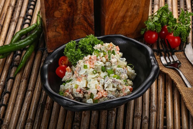 Traditional Russian salad with mayonnaise meat potato and peas