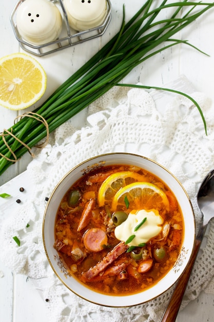 Traditional Russian soup Solyanka with meat sausages vegetables capers pickles Top view