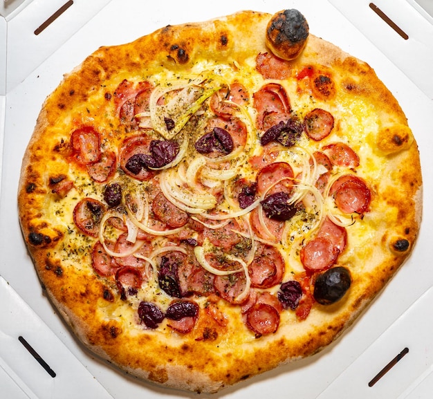 Traditional rustic pizza with pepperoni black olives onion and basil Isolated pizza