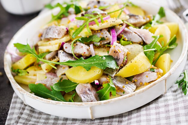 Фото Традиционный салат из филе сельди, свежих яблок, красного лука и картофеля. кошерная еда. скандинавская кухня.