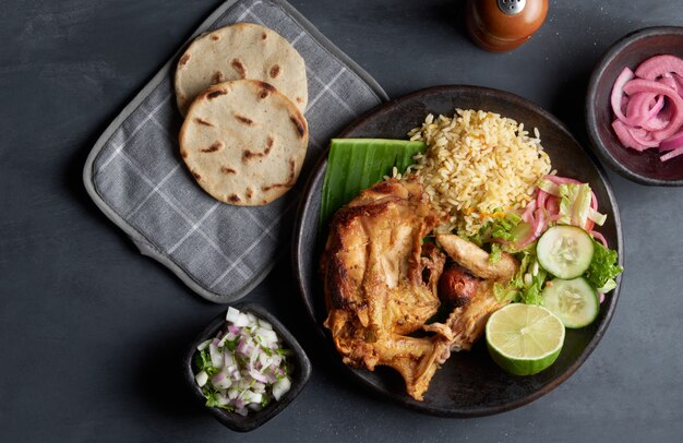 Gallina arrosto piatto tradizionale salvadoregno servito con tortillas di riso, limone, cipolla e mais, cibo dell'america latina