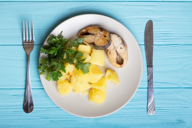 Традиционный скандинавский ужин - отварной картофель и скумбрия на синем фоне