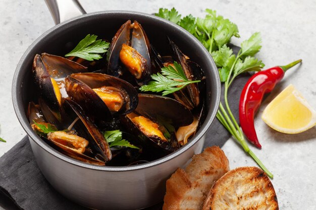Traditional seafood mussels in wine sauce and toasts