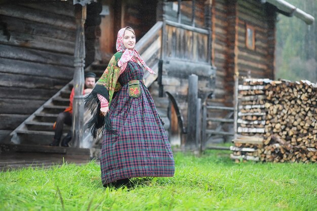 Traditional slavic rituals in the rustic style outdoor in\
summer slavic village farm peasants in elegant robes