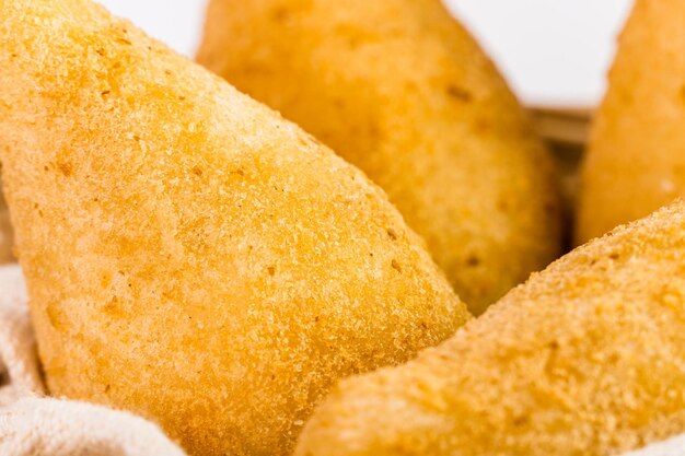 Traditional snacks Chicken Coxinha known as Coxinha in Brazil Served in a basket White background Selective focus