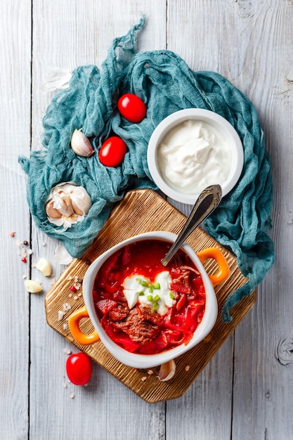 Traditional soup of Russian and Ukrainian cuisine borsch. Meat soup with beets in an orange bowl. Top view.