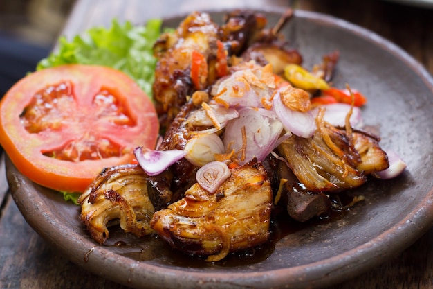 Pollo alla griglia con salsa di soia tradizionale servito su un piatto di terracotta