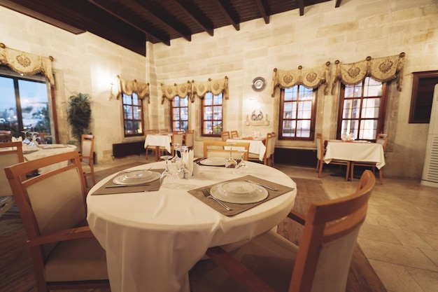 Traditional spacious interior of modern empty large restaurant with tables and chairs