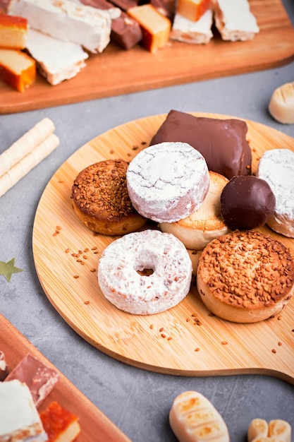 Traditional Spanish Christmas sweets turron, polvorones, mantecados with Christmas decor on grey table top