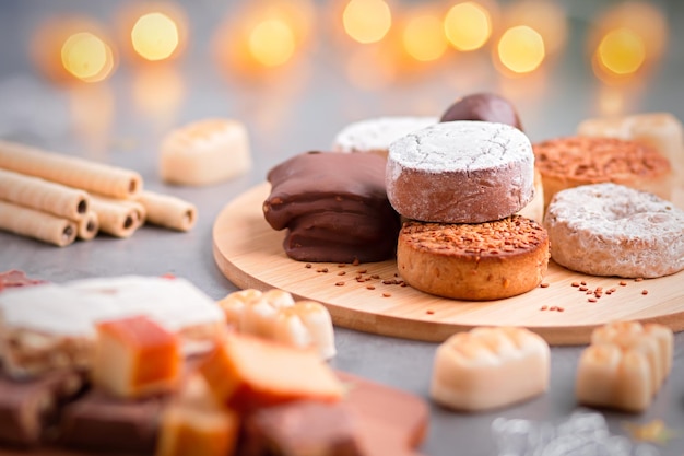 Photo traditional spanish christmas sweets turron, polvorones, mantecados with christmas decor on grey table top