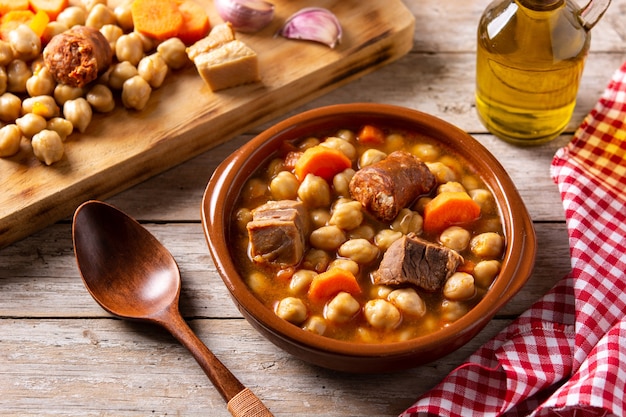 Traditional Spanish cocido madrileÃÂ±o. Chickpea stew on wooden table