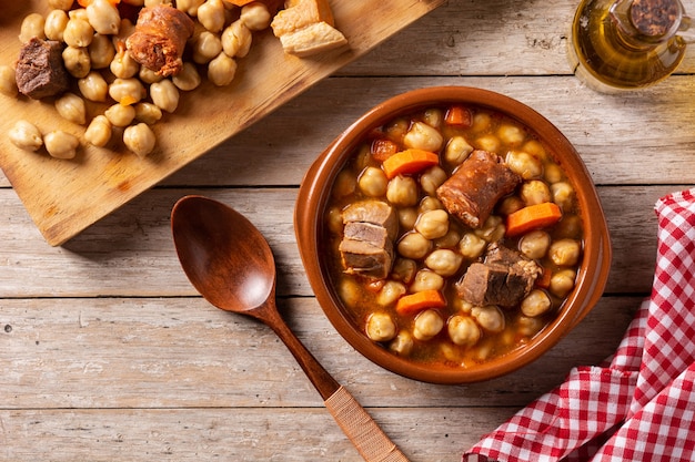 Traditional Spanish cocido madrileÃÂ±o. Chickpea stew on wooden table