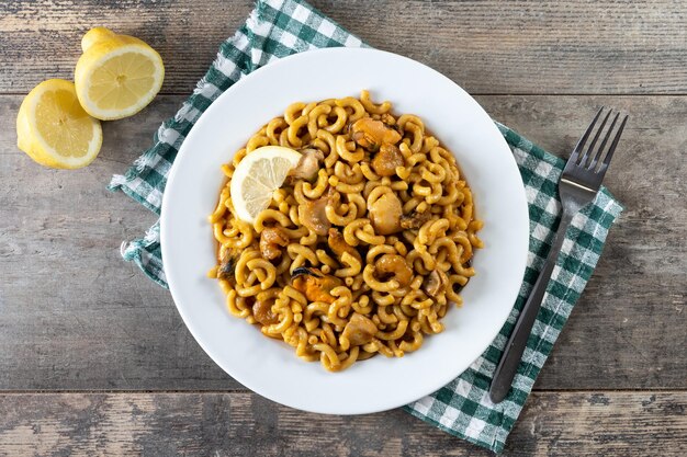 Traditional Spanish fideua Noodle paella on wooden table