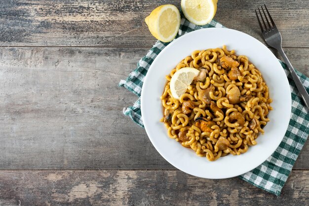 Paella tradizionale spagnola della tagliatella di fideua sulla tavola di legno