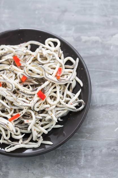 Traditional Spanish food. Gulas with oil on white plate.