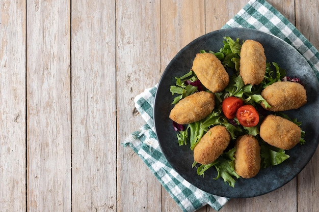 Traditional spanish fried croquettes on wooden table