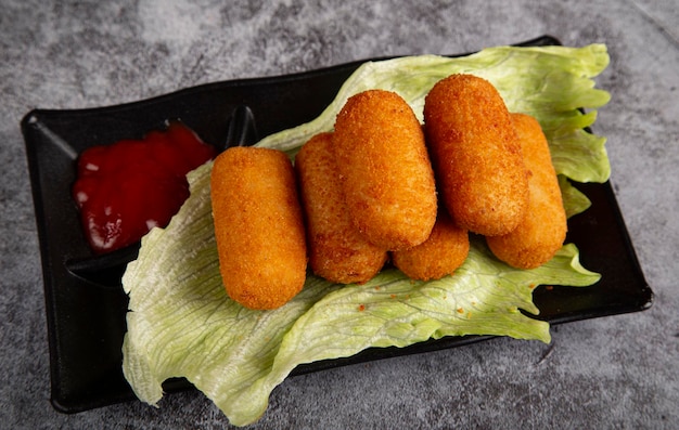 Traditional Spanish homemade croquetas or croquettes on a plate on a lettuce leaf