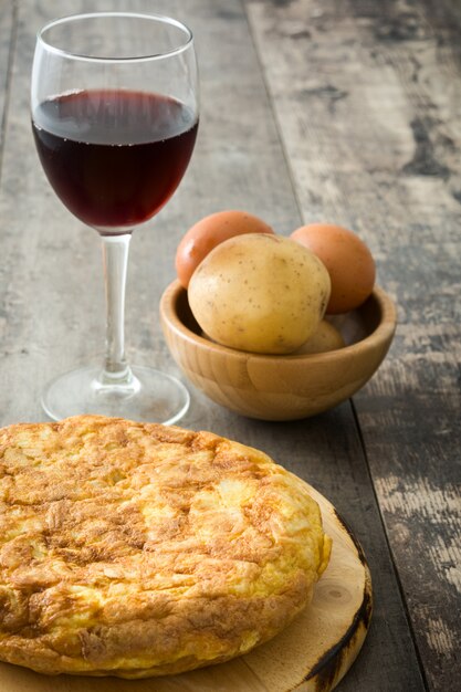 Traditional spanish omelette and wine cup on wooden table