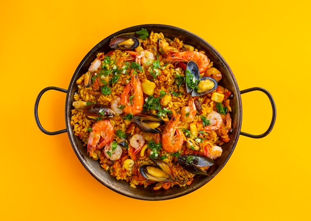 Paella spagnola tradizionale dei frutti di mare nella padella su un fondo