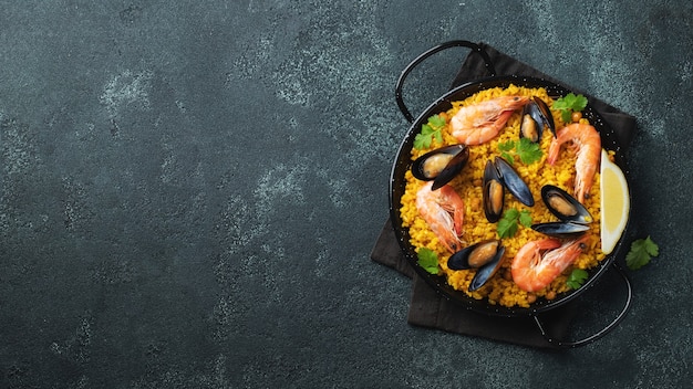 Traditional spanish seafood paella in pan.