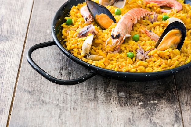 Paella spagnola tradizionale dei frutti di mare su legno