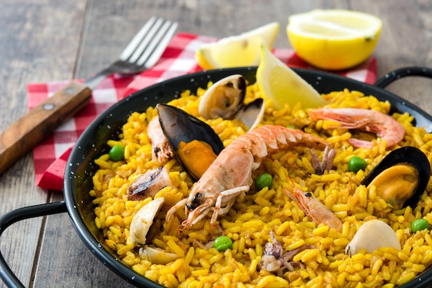 Traditional spanish seafood paella on wooden table close up