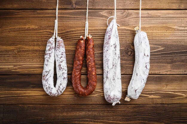 Traditional spanish smoked sausages meat hanging on light wooden background.