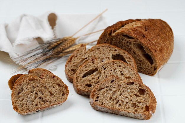 traditional spelled sourdough bread cut into slices on a white wooden background sliced