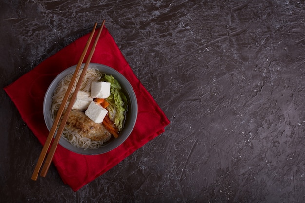 豆腐チーズと麺の伝統的なスパイシーなアジアスープ