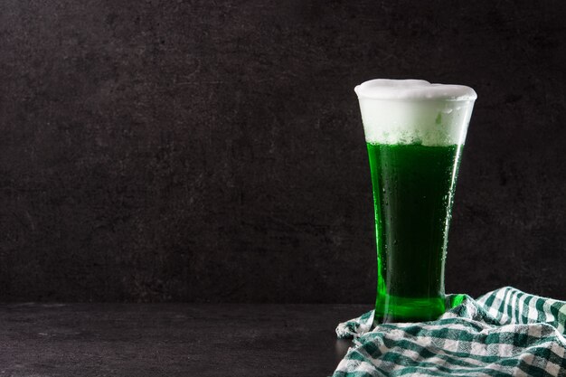 Traditional St Patrick's Day green beer on black background Copy space