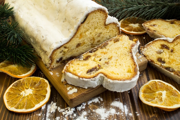 Traditional stollen and dried orange  on the wooden surface