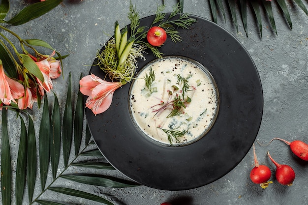 Traditional summer Russian cold soup with kvass, okroshka with ham and vegetables, food.