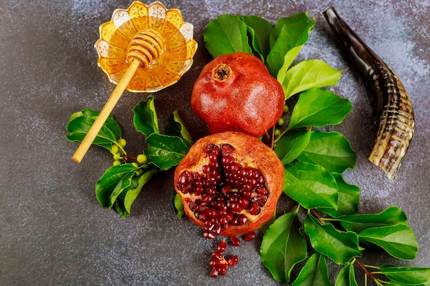 Traditional sweet honey with wooden stick and fruits for jewish holiday Rosh Hashanah.