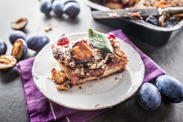 The traditional sweet plum cake on white plate.