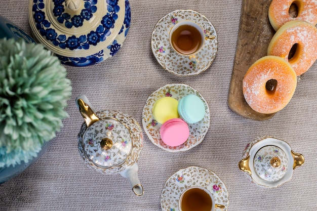 Traditional table with cup of tea and tea pot and colorful macaron lovely cozy table at home,Mother's Day tea setting with teapot,