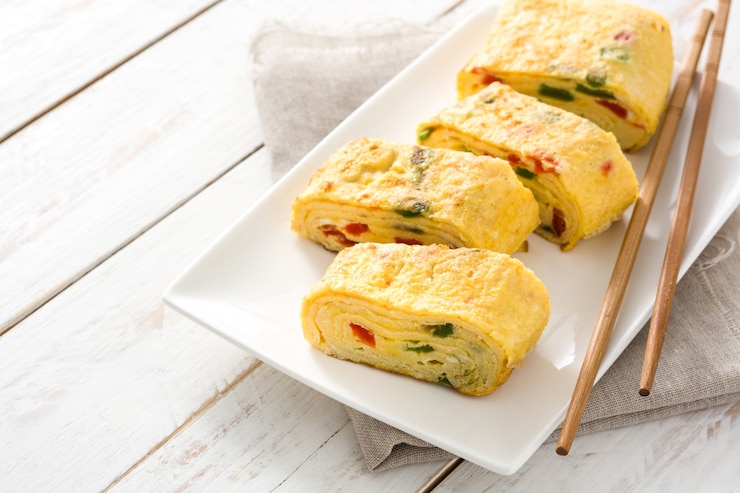Photo 흰색 나무 테이블에 전통적인 tamagoyaki 일본 오믈렛.